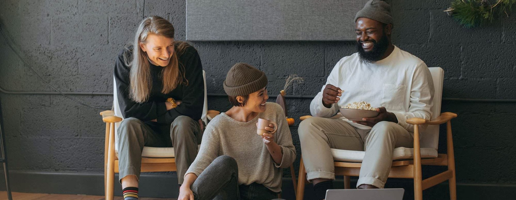 three people laughing and looking at a computer